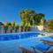 Outdoor swimming pool at Grande Kloof with sunloungers and parasols