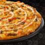 Large Chicken & Mushroom pizza from Debonairs Pizza placed on top of a black plate, on a black background, with shape patterns.