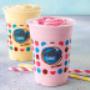 Milky Lane Double Thick milkshakes in strawberry and banana flavour on a grey surface with against a blue background.
