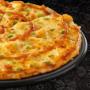 Large Sweet & Sour Chicken pizza from Debonairs Pizza placed on top of a black plate, on a black background, with shape patterns.