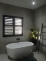 Charcoal Bathroom Shutters installed by In Style Blinds .