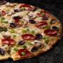 Large Four Seasons pizza from Debonairs Pizza placed on top of a black plate, on a black background, with shape patterns.